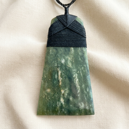 Nui Toki pendant on simple off-white linen